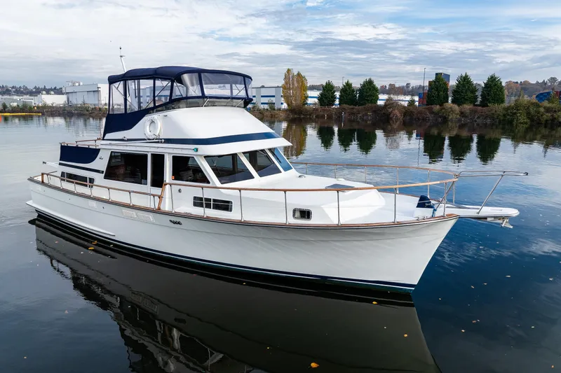 The Image of 1991 Tollycraft 48 Cockpit Motor Yacht on calm water, showcasing elegant design and spacious deck. - 0