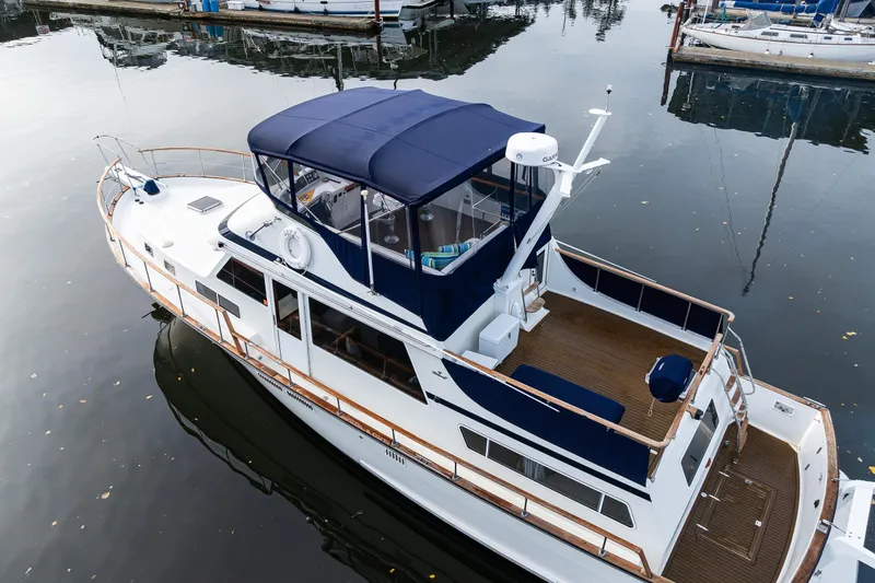 Slide: The Image of 1991 Tollycraft 48 Cockpit Motor Yacht docked in calm marina waters. - 10