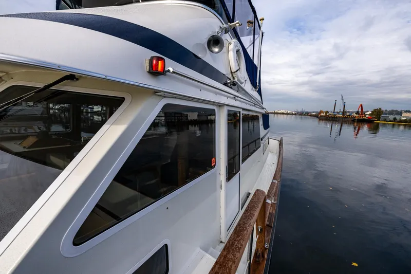 Slide: The Image of 1991 Tollycraft 48 Cockpit Motor Yacht on calm waters, side view. - 15