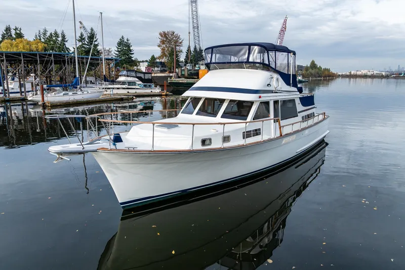 Slide: The Image of 1991 Tollycraft 48 Cockpit Motor Yacht docked in a serene marina setting. - 2
