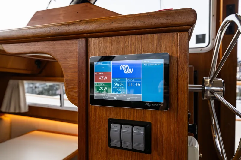 Slide: The Image of 1991 Tollycraft 48 Cockpit Motor Yacht helm with digital display and wooden finish. - 25
