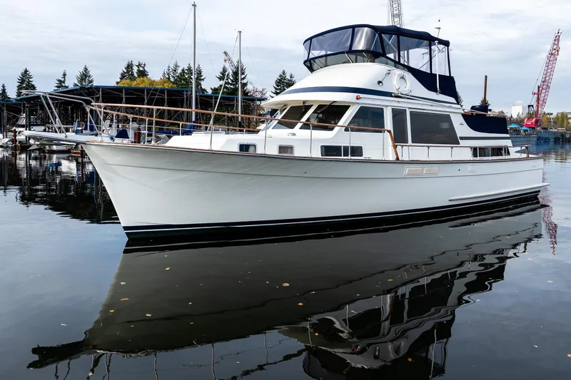 Slide: The Image of 1991 Tollycraft 48 Cockpit Motor Yacht docked in a serene marina setting. - 3