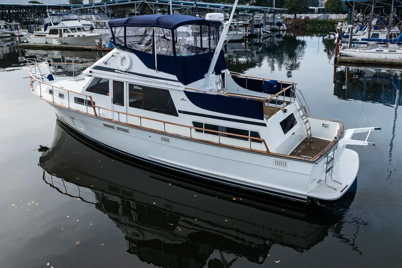 Slide: The Image of 1991 Tollycraft 48 Cockpit Motor Yacht docked in a marina, reflecting on calm water. - 4