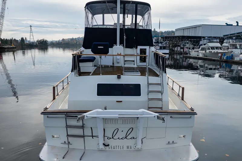 Slide: The Image of 1991 Tollycraft 48 Cockpit Motor Yacht docked in a serene marina setting. - 5