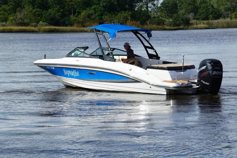 Slide: The Image of 2015 Sea Ray 21 SPX OB boat with blue canopy cruising on a calm lake. - 0