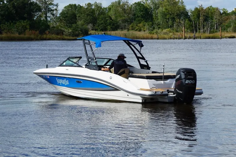 Slide: The Image of 2015 Sea Ray 21 SPX OB boat cruising on a calm river with lush greenery. - 11