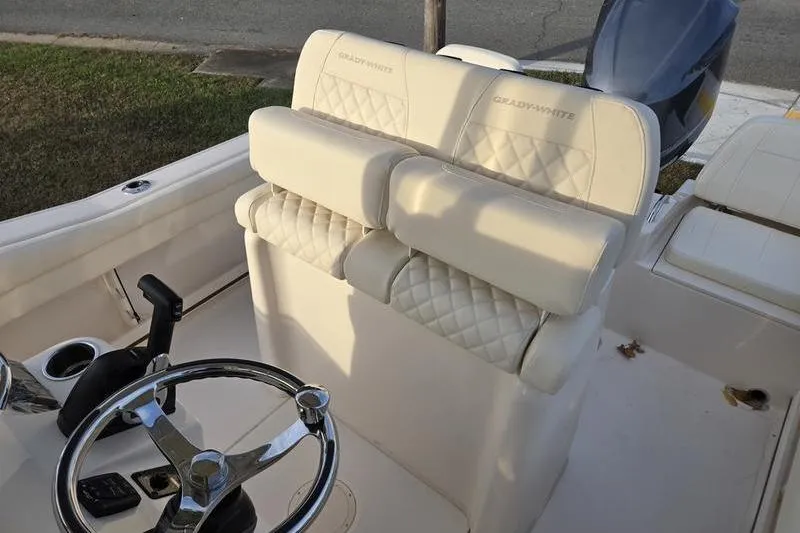 Slide: The Image of 2026 Grady-White Fisherman 216 boat interior with steering wheel and cushioned seating. - 10