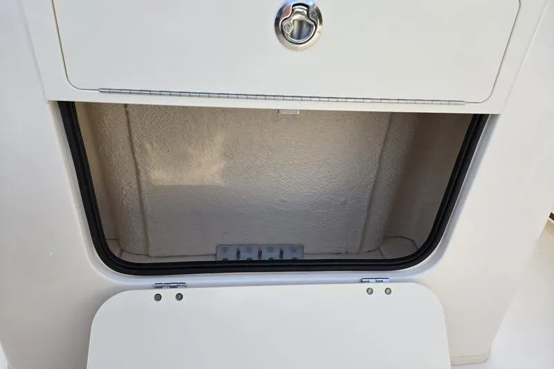 Slide: The Image of Storage compartment on 2026 Grady-White Fisherman 216 boat, featuring secure latch. - 17