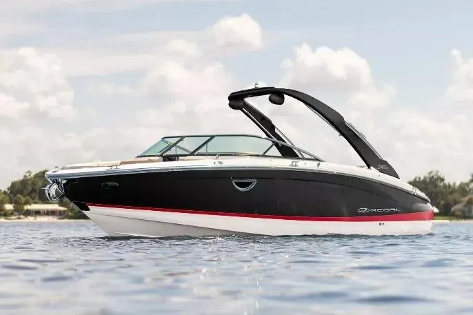 The Image of 2025 Regal LS6 boat on water, sleek black and white design, sunny day. - 0