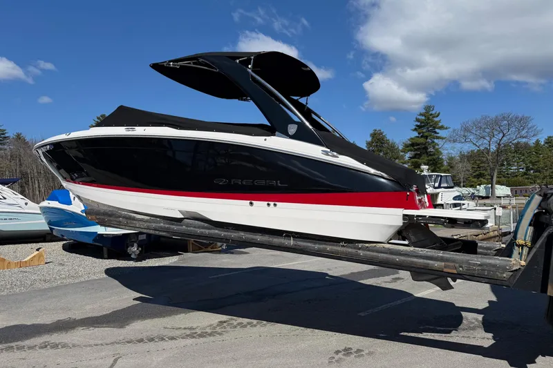 Slide: The Image of 2025 Regal LS6 boat on trailer under clear blue sky. - 21