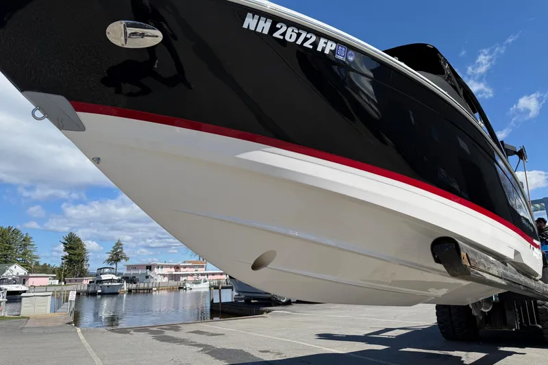 Slide: The Image of 2025 Regal LS6 boat on trailer, dockside, under clear blue sky. - 24