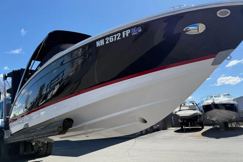 Slide: The Image of 2025 Regal LS6 boat with sleek black and white design, docked under clear blue sky. - 25