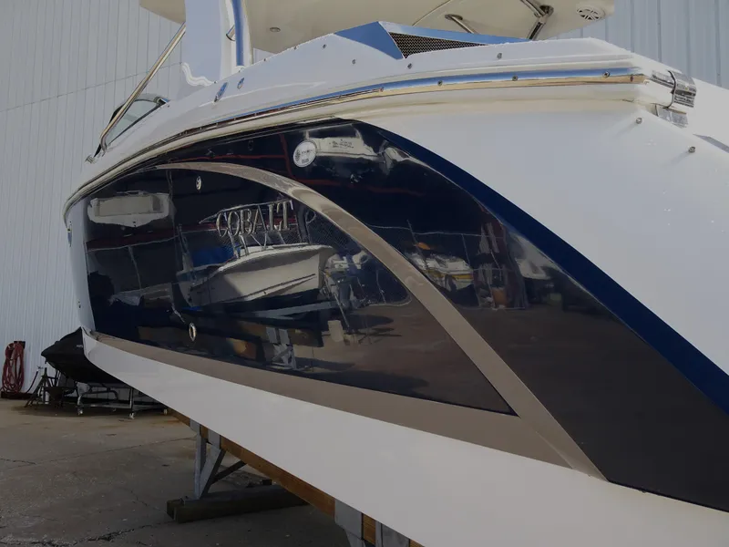 Slide: The Image of 2018 Cobalt R30 boat with sleek blue and white exterior, docked in a marina. - 6