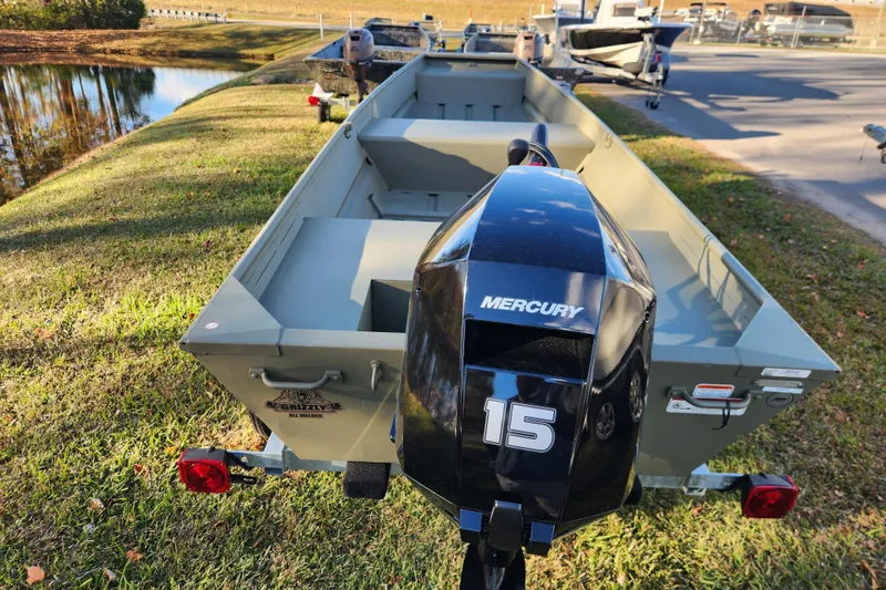 Slide: The Image of 2026 Tracker Grizzly 1436 Utility boat with Mercury 15 outboard motor on grass. - 2