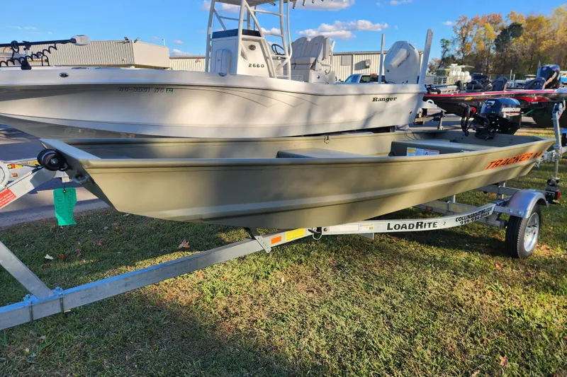 Slide: The Image of 2026 Tracker Grizzly 1436 Utility boat on LoadRite trailer, displayed outdoors. - 4