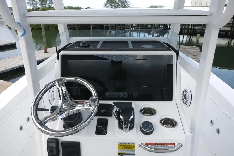 Slide: The Image of 2024 Crevalle 26 HCO boat console with steering wheel and navigation controls. - 17
