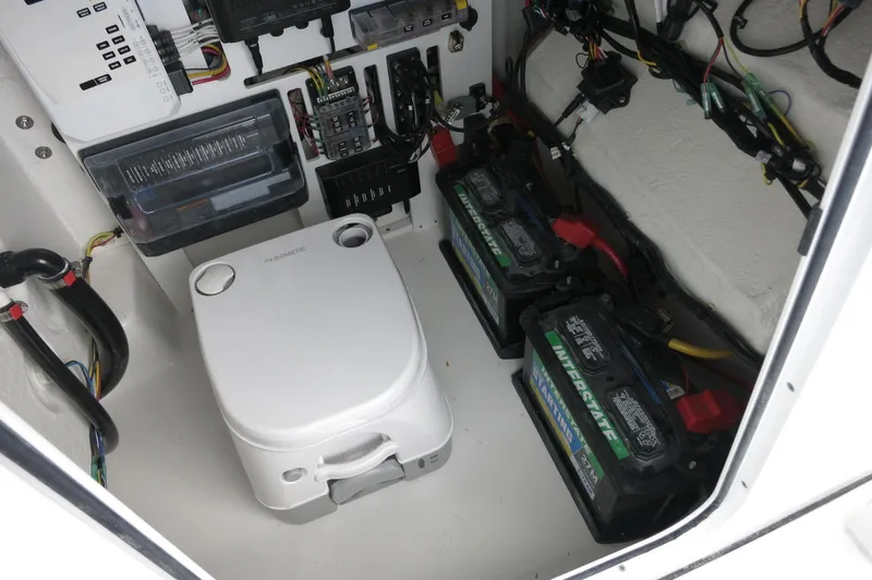 Slide: The Image of 2024 Crevalle 26 HCO boat electrical compartment with batteries and wiring. - 19
