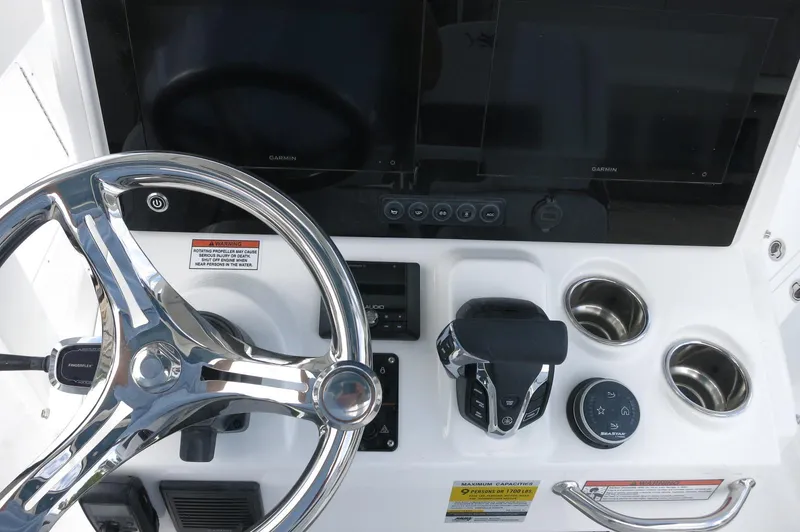 Slide: The Image of 2024 Crevalle 26 HCO boat helm with steering wheel and controls. - 24