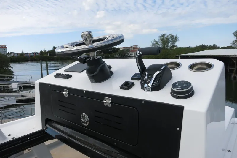 Slide: The Image of 2024 Crevalle 26 HCO boat console with steering wheel and controls. - 26