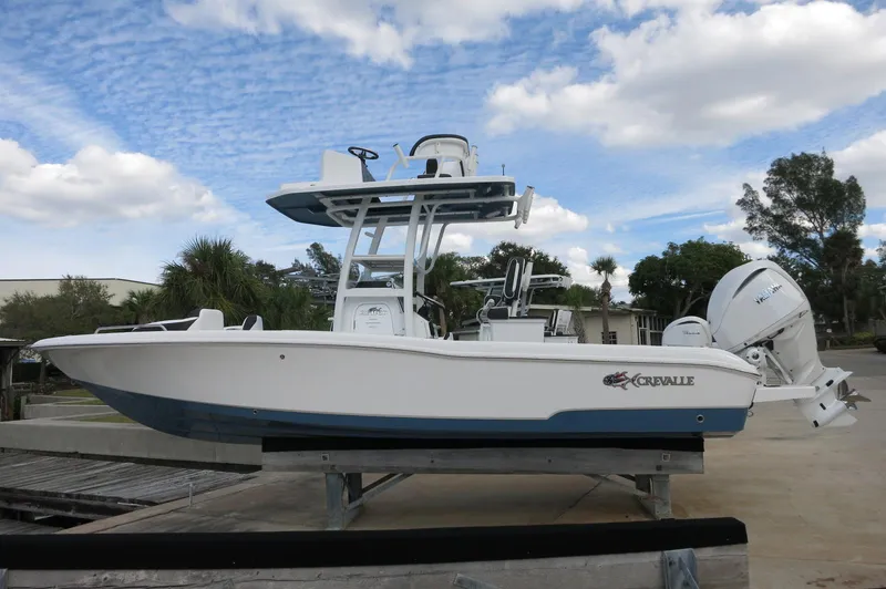 Slide: The Image of 2024 Crevalle 26 HCO boat on a dock with a blue and white hull. - 6
