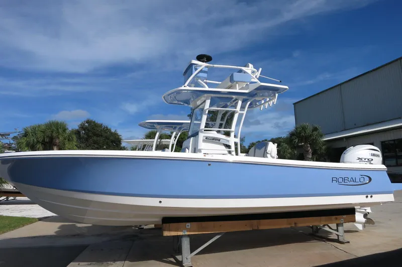 The Image of 2024 Robalo R266 Skydeck boat on display, blue and white exterior. - 0
