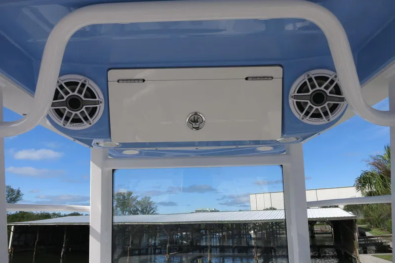 Slide: The Image of 2024 Robalo R266 Skydeck boat with overhead speakers and storage compartment. - 16