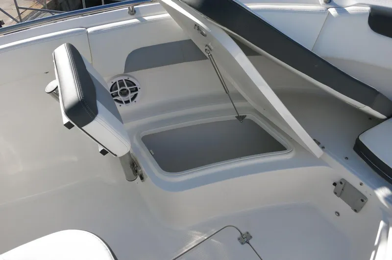 Slide: The Image of 2024 Robalo 222 Explorer CC boat storage compartment with open seat. - 13