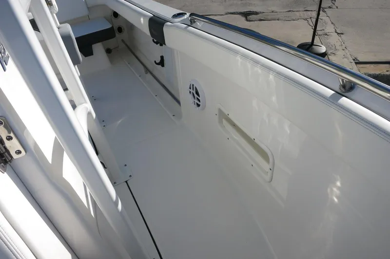 Slide: The Image of 2024 Robalo 222 Explorer CC boat interior, white deck and side rail. - 20