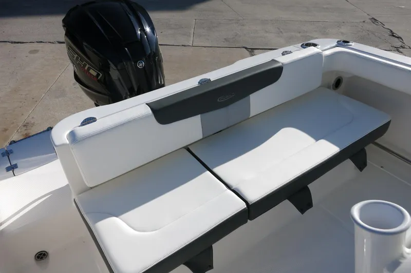 Slide: The Image of 2024 Robalo 222 Explorer CC boat with cushioned seating and outboard motor. - 28