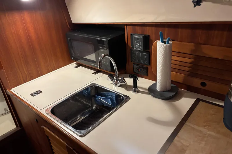 Slide: The Image of 2003 Hinckley 36 Picnic Boat EP galley with sink, microwave, and paper towel holder. - 8
