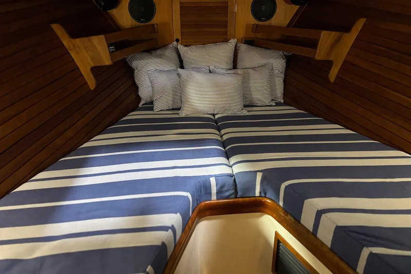 Slide: The Image of 2003 Hinckley 36 Picnic Boat EP cabin with striped bedding and wooden interior. - 11