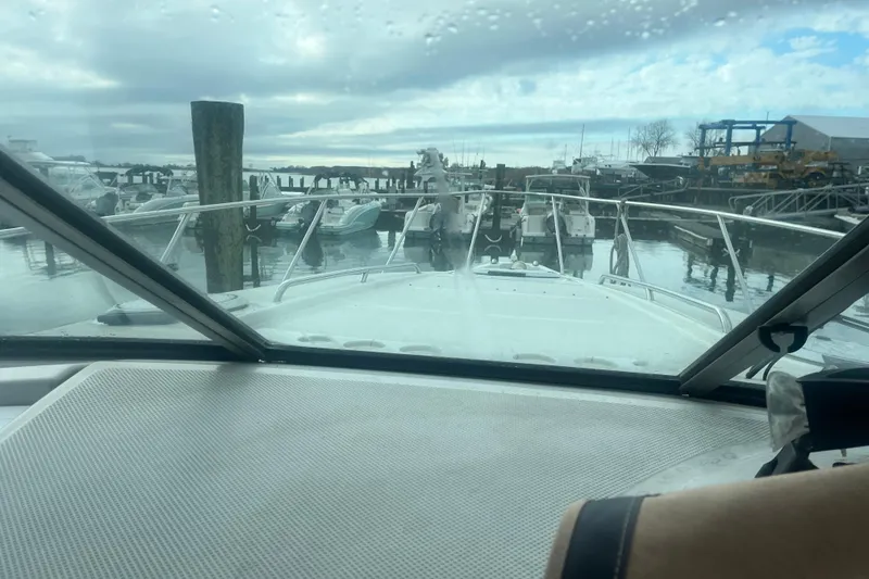 Slide: The Image of 1998 Maxum 3000SCR boat docked at marina, viewed from cockpit under cloudy sky. - 32