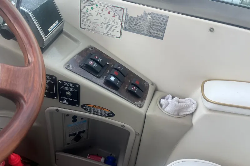 Slide: The Image of Control panel of a 1998 Maxum 3000SCR boat with switches and steering wheel. - 33