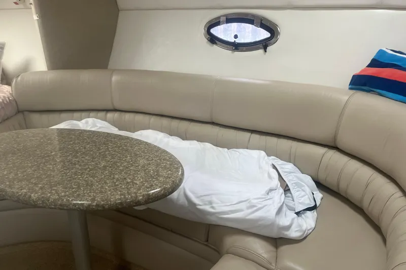 Slide: The Image of Interior of 1998 Maxum 3000SCR boat with beige seating and round table. - 47