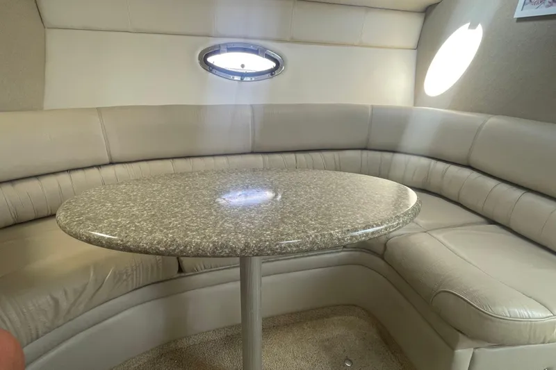 Slide: The Image of Interior of 1998 Maxum 3000SCR boat with cushioned seating and round table. - 68