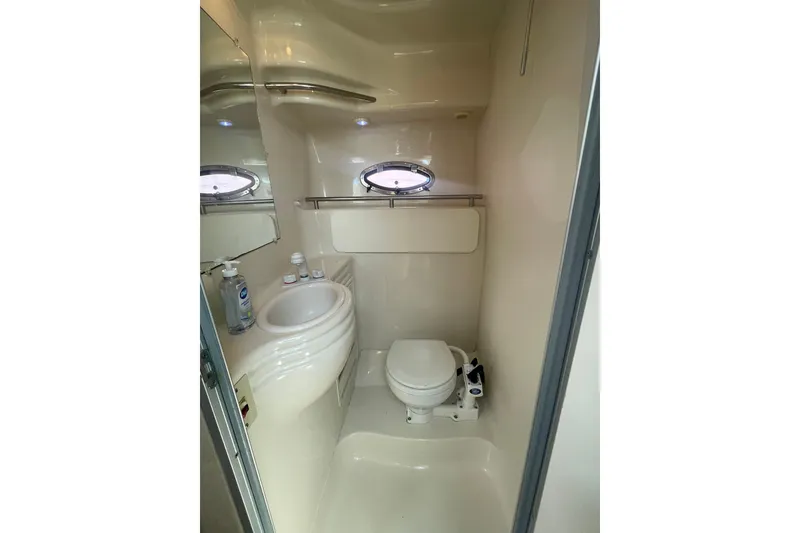 Slide: The Image of 1998 Maxum 3000SCR boat bathroom with sink, toilet, and porthole window. - 72