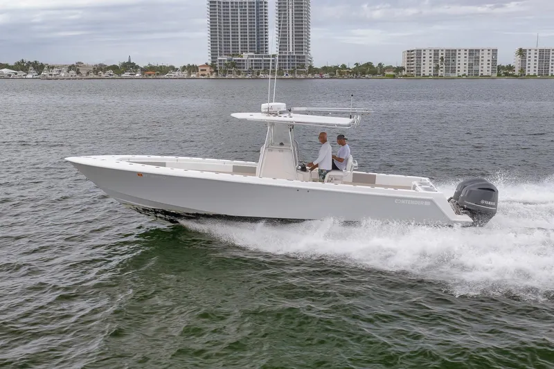 Slide: The Image of 2012 Contender 32 Tournament boat cruising on water with cityscape background. - 22