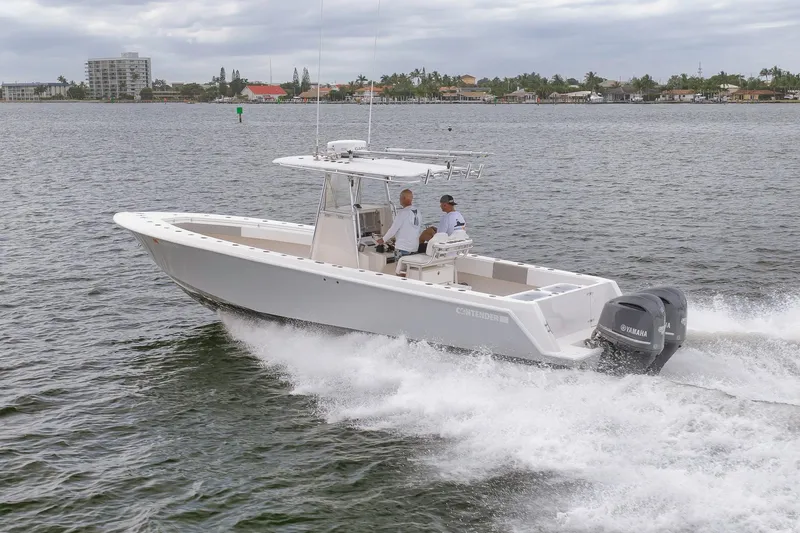 Slide: The Image of 2012 Contender 32 Tournament boat cruising on water with two people onboard. - 23