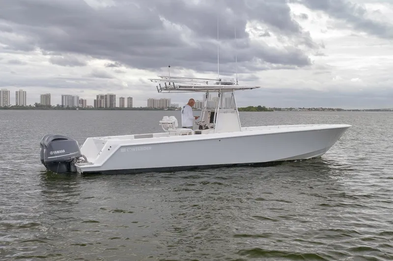 Slide: The Image of 2012 Contender 32 Tournament boat on water with Yamaha engine, cloudy sky backdrop. - 3
