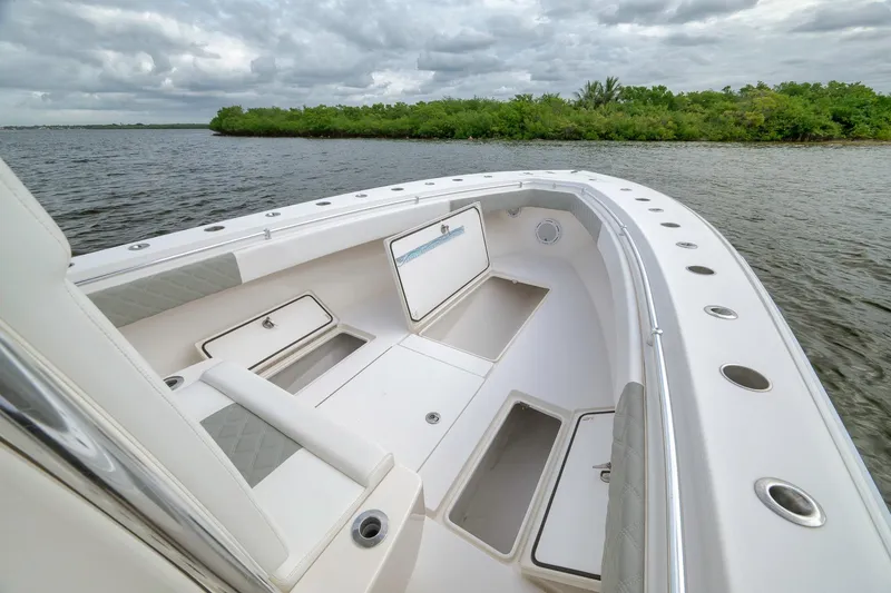 Slide: The Image of 2012 Contender 32 Tournament boat interior with open storage compartments on calm water. - 34