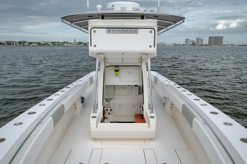Slide: The Image of 2012 Contender 32 Tournament boat on water, open storage compartment, coastal background. - 43