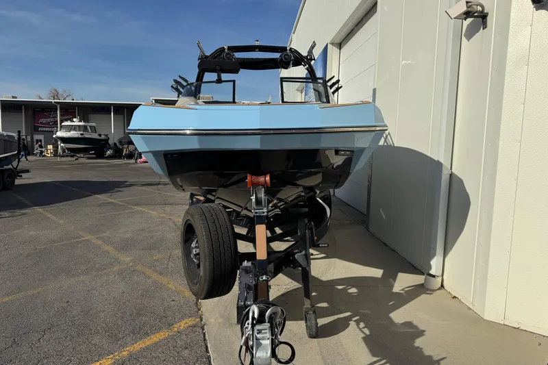 Slide: The Image of 2024 Moomba Tykon boat on trailer, parked outside a building under clear skies. - 4