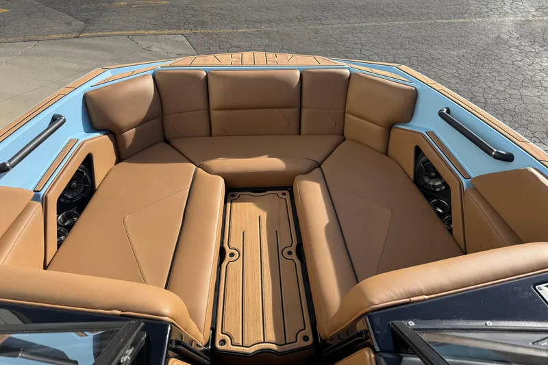 Slide: The Image of 2024 Moomba Tykon boat interior with tan seating and blue accents. - 6
