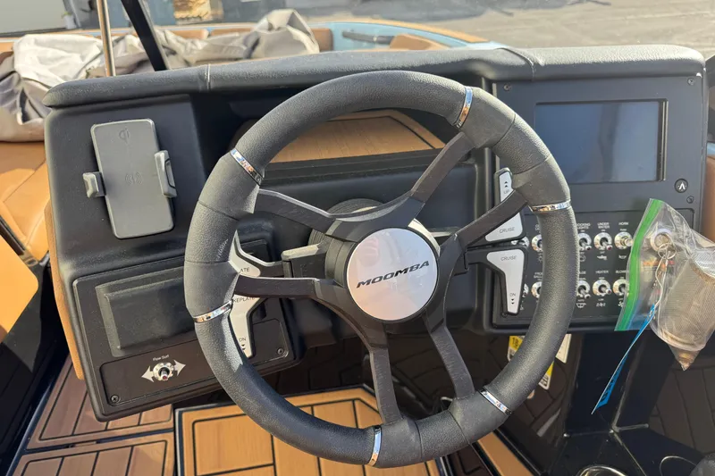 Slide: The Image of 2024 Moomba Tykon boat dashboard with steering wheel and control panel. - 7