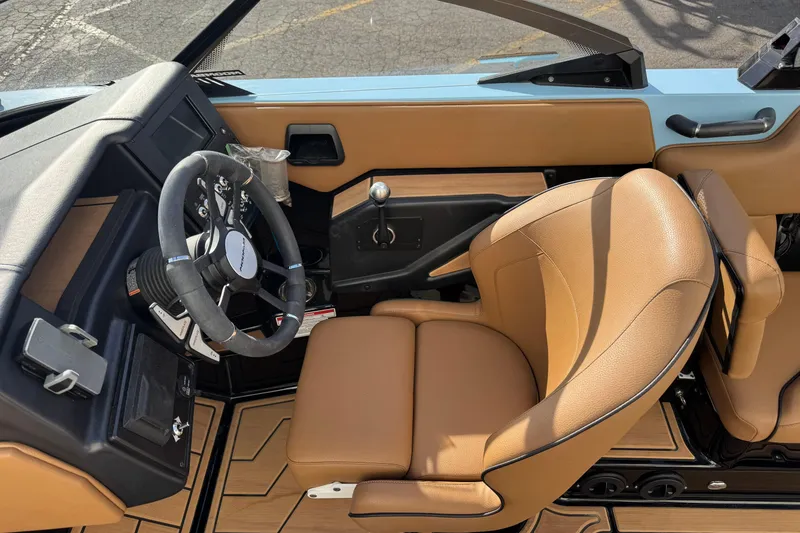 Slide: The Image of 2024 Moomba Tykon boat interior with tan leather seats and modern steering wheel. - 8