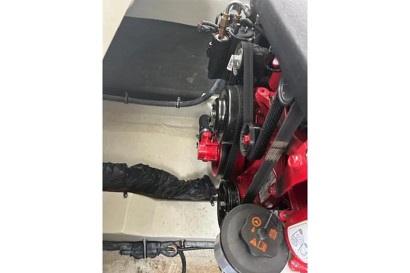 Slide: The Image of Engine compartment of a 2014 Cobalt 302 boat, showcasing belts and components. - 13