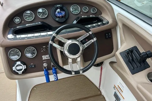 Slide: The Image of 2014 Cobalt 302 boat dashboard with steering wheel and control panel. - 22