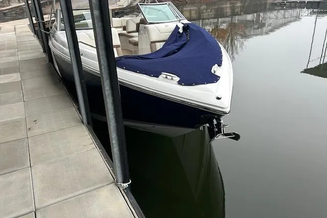 Slide: The Image of 2014 Cobalt 302 boat docked, covered with a blue tarp, reflecting on calm water. - 24