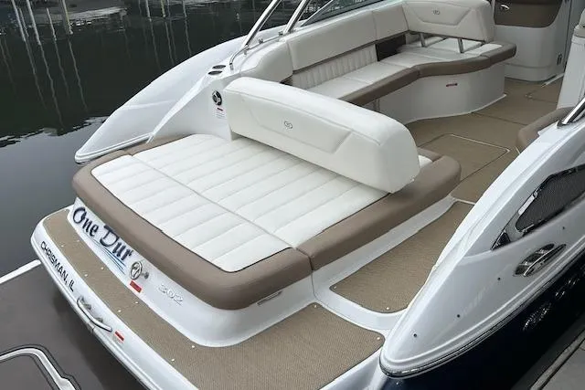 Slide: The Image of 2014 Cobalt 302 boat with white and beige seating, docked on calm water. - 4