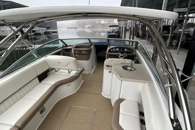 Slide: The Image of 2014 Cobalt 302 boat interior with beige and white seating, helm, and sink area. - 5